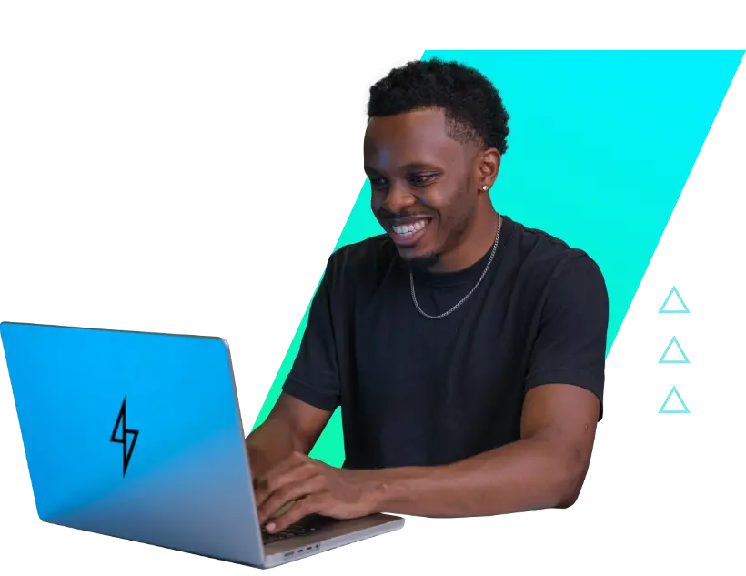 Black man wearing a black t-shirt and a silver necklace, smiling while using a laptop with a Rebel logo. He appears to be working, with a skewed rectangle shape and gradient background behind him